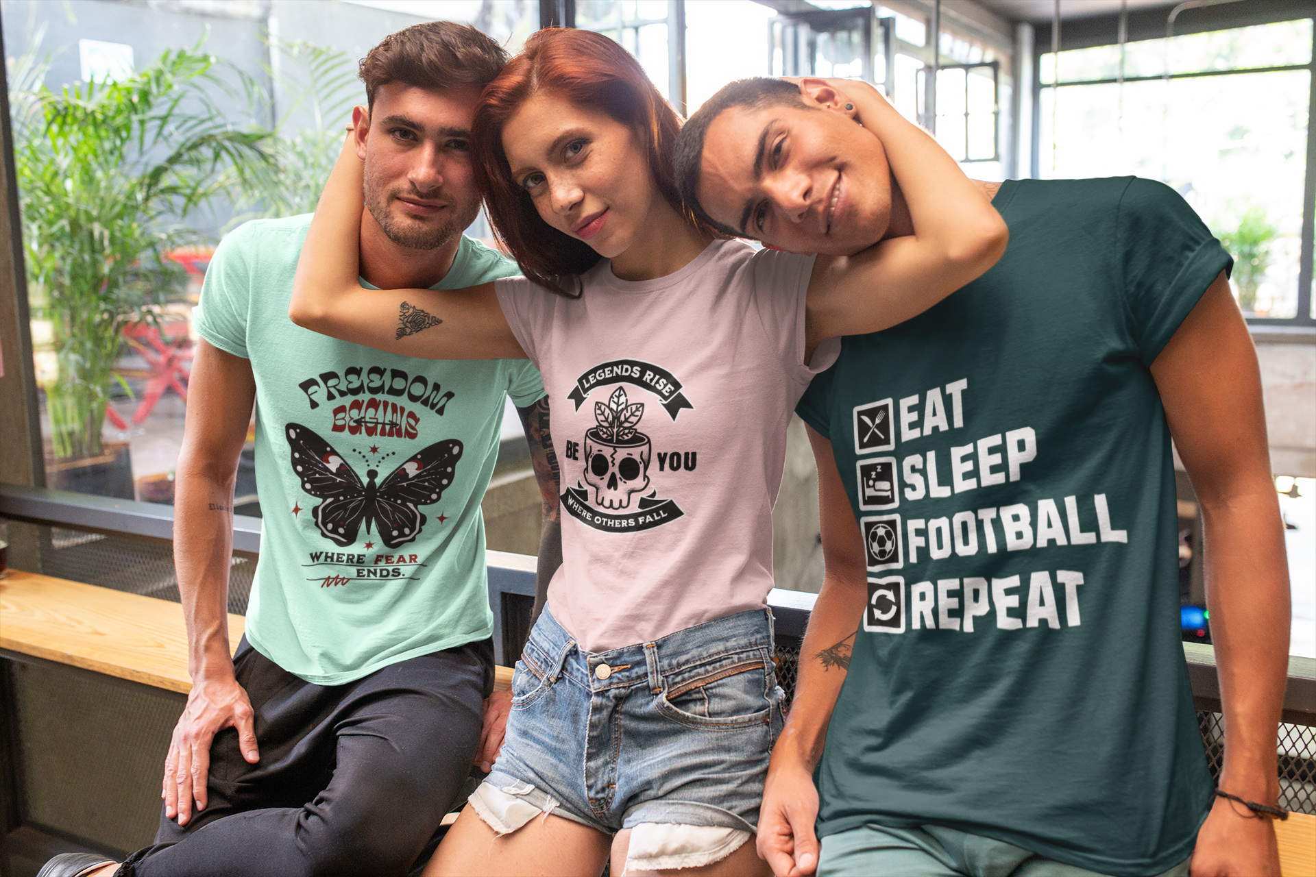 Three people wearing t-shirts with different designs in an indoor setting.