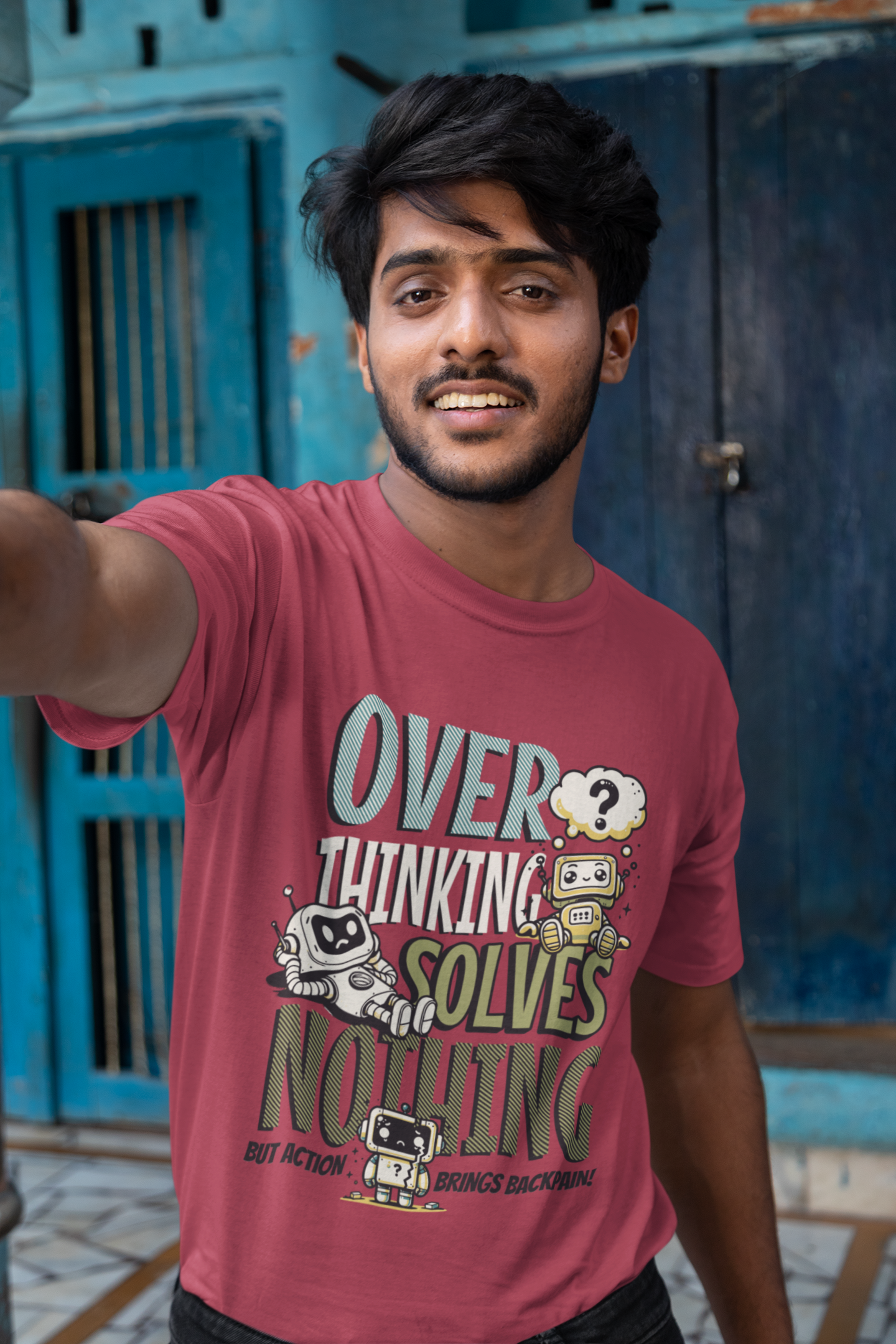 Person wearing a red t-shirt with text and graphics, standing in front of a blue door.