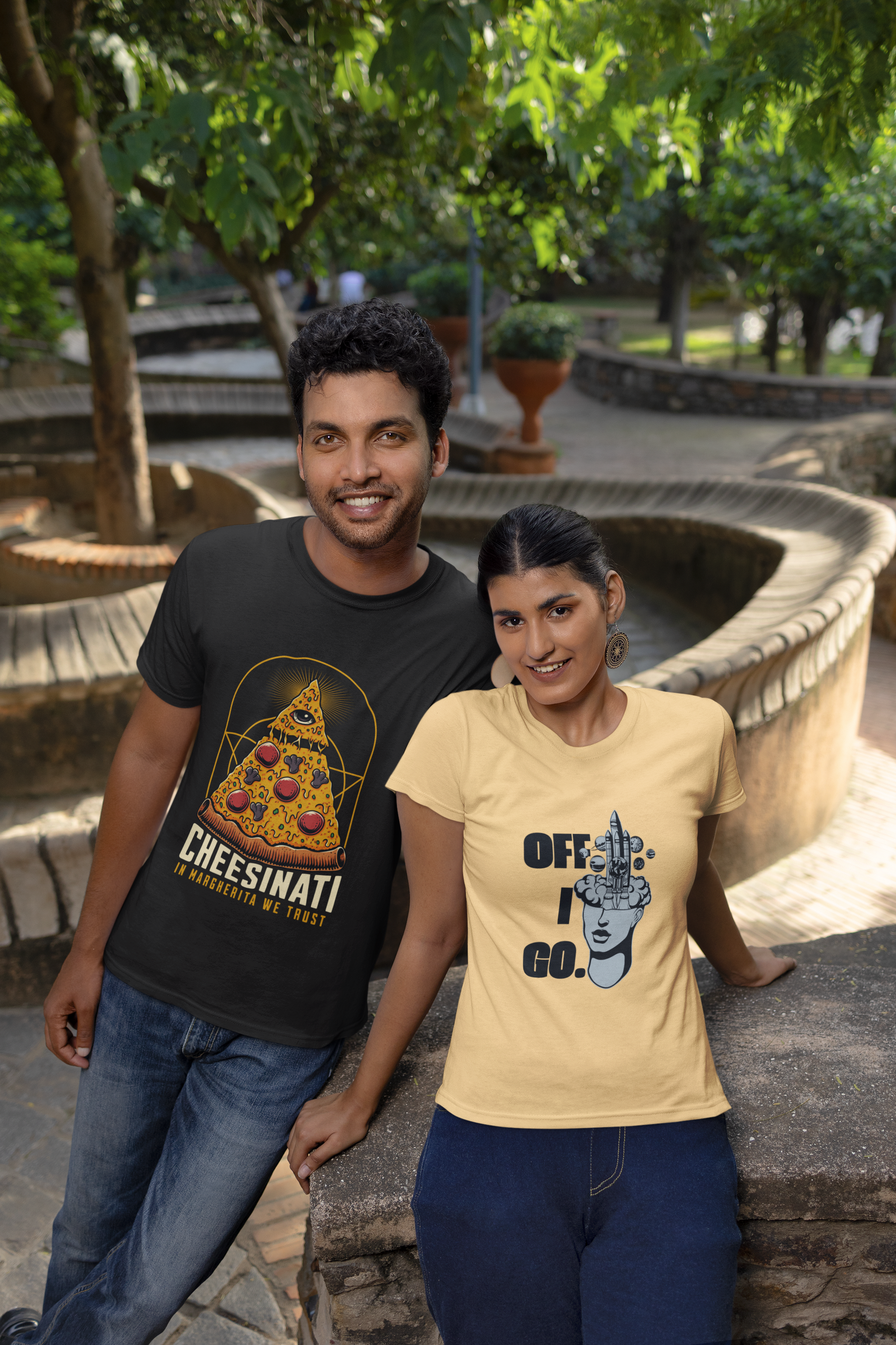 Two people standing outdoors with t-shirts featuring graphics and text.