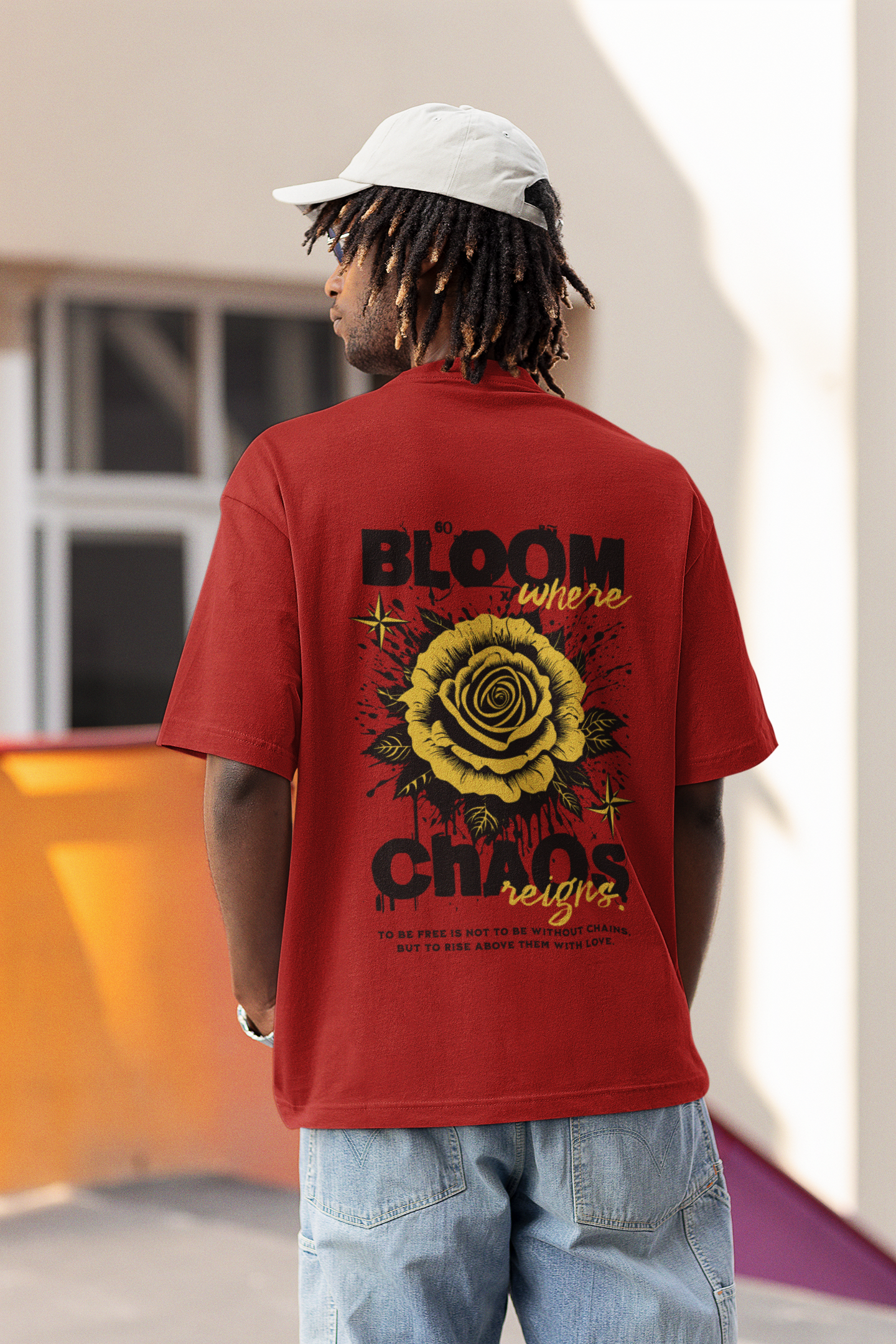 Person wearing a red t-shirt with a graphic design and text, standing outdoors.
