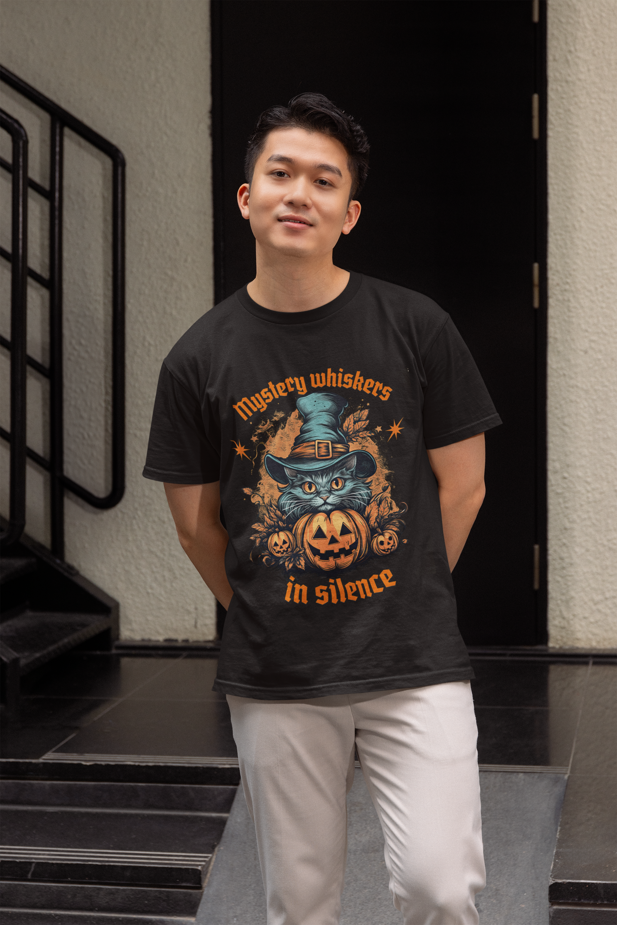 Person in black tee with a cat in witch hat and pumpkin, text 'Mystical whiskers in silence', standing near a dark door.