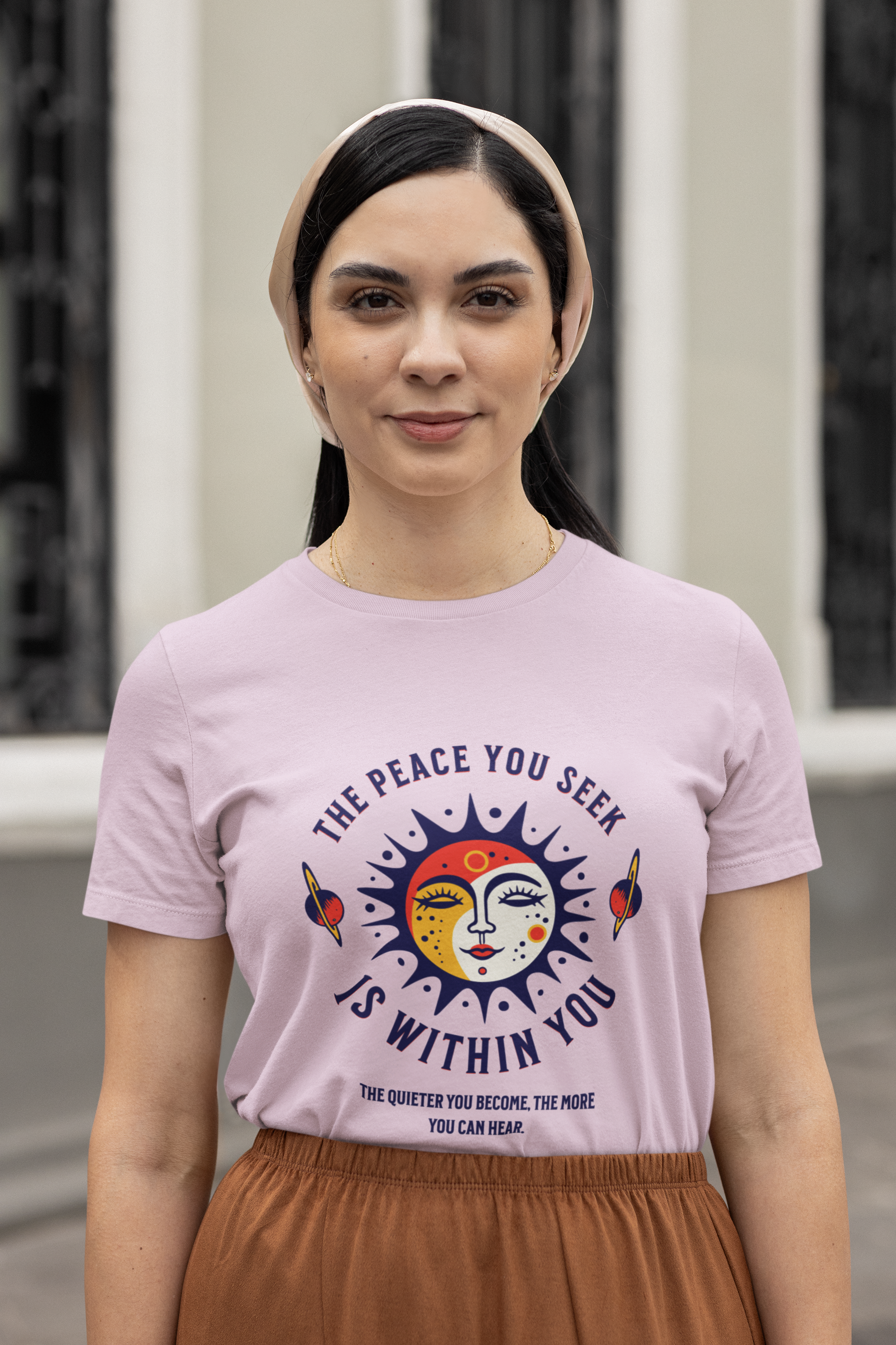 Woman wearing a pink t-shirt with a peace symbol design and text.
