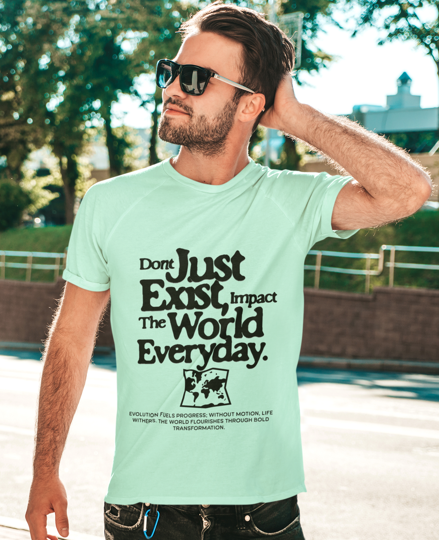 Man wearing a light green t-shirt with motivational text outdoors
